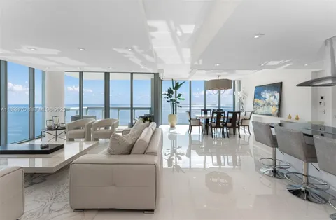 a living room with furniture large window and glass table