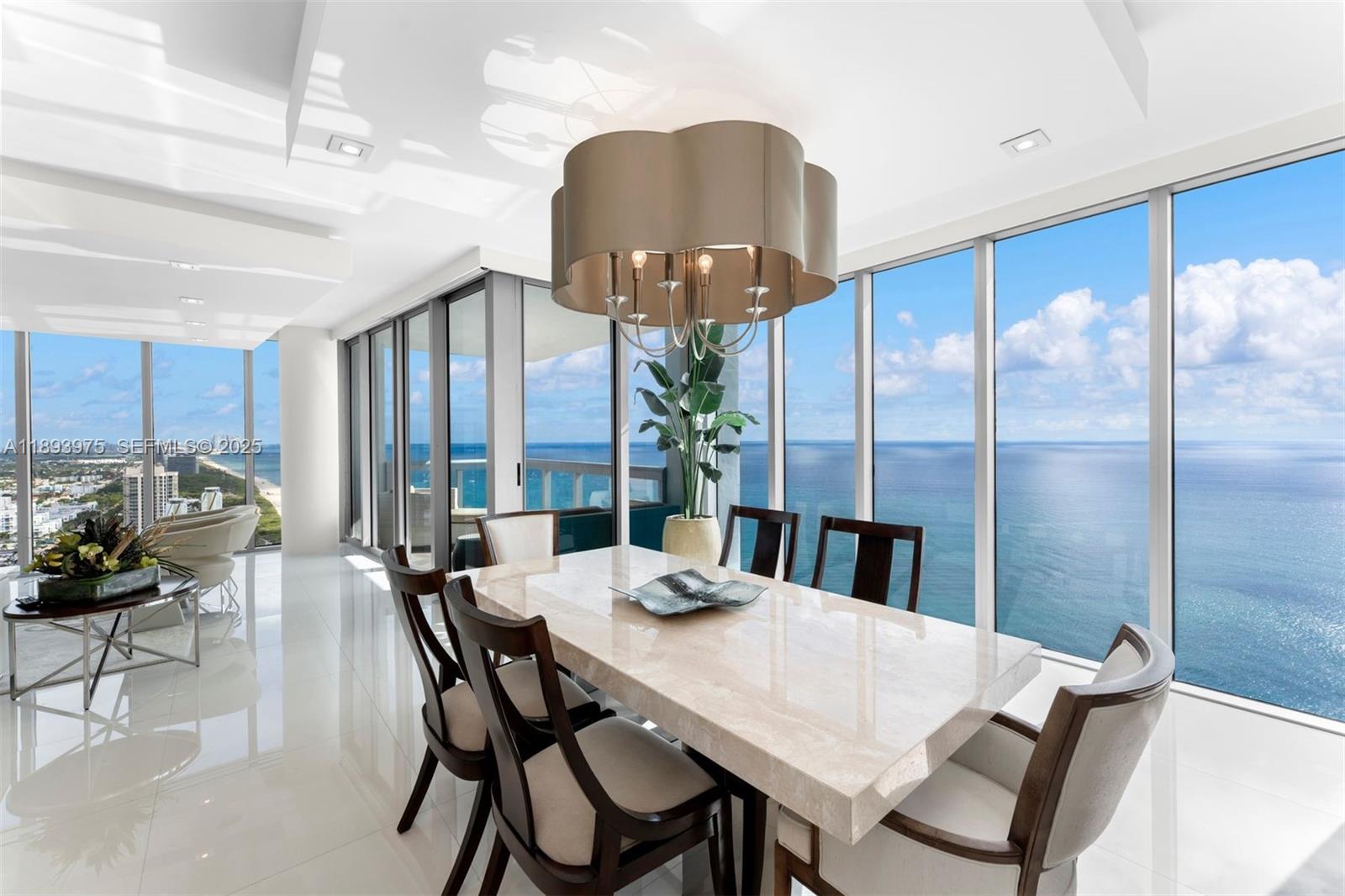 6899 Collins Avenue, Unit LPH04 Miami Beach, FL 33141 - Photo 4 of 29 a view of a dining room with furniture window and wooden floor