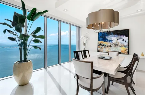 a dining room with furniture and a potted plant