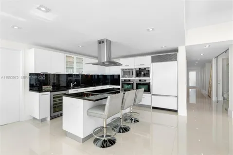 a kitchen with stainless steel appliances kitchen island granite countertop a refrigerator and a stove top oven