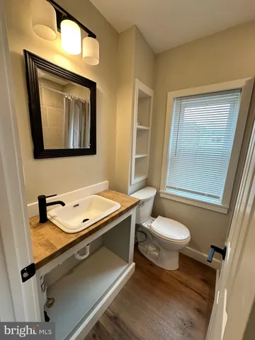 a bathroom with a toilet sink and mirror