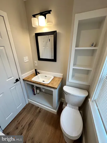 a view of bathroom with a toilet sink and mirror