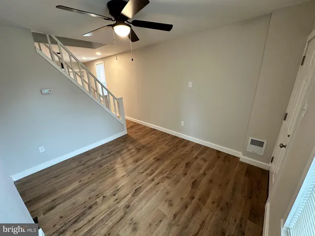 wooden floor in an empty room with a chandelier