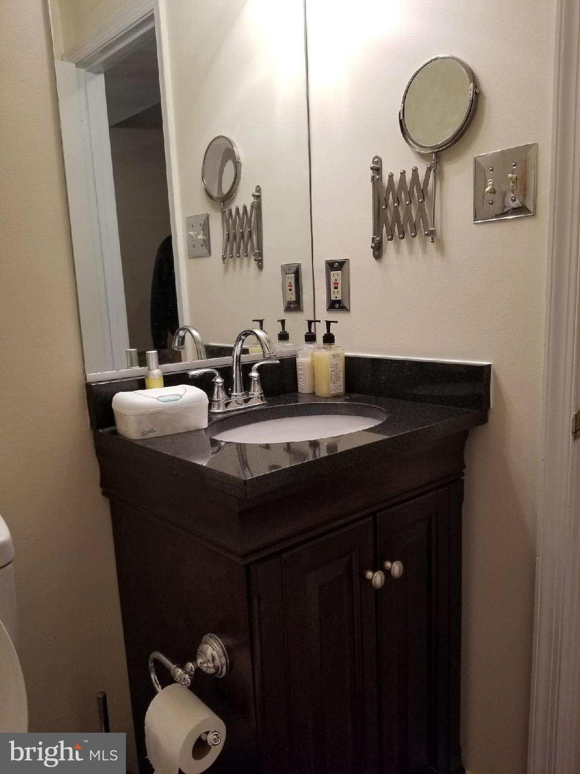 1101 Marksworth Road Baltimore, MD 21207 - Photo 22 of 29 a bathroom with a granite countertop sink and a mirror