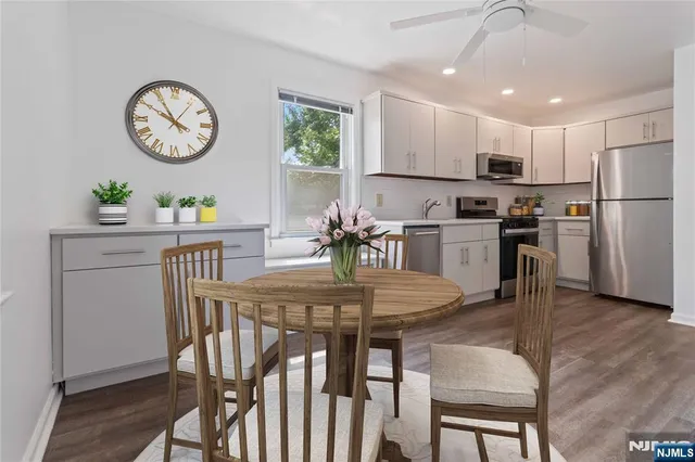 a view of a dining room with furniture a kitchen and chandelier