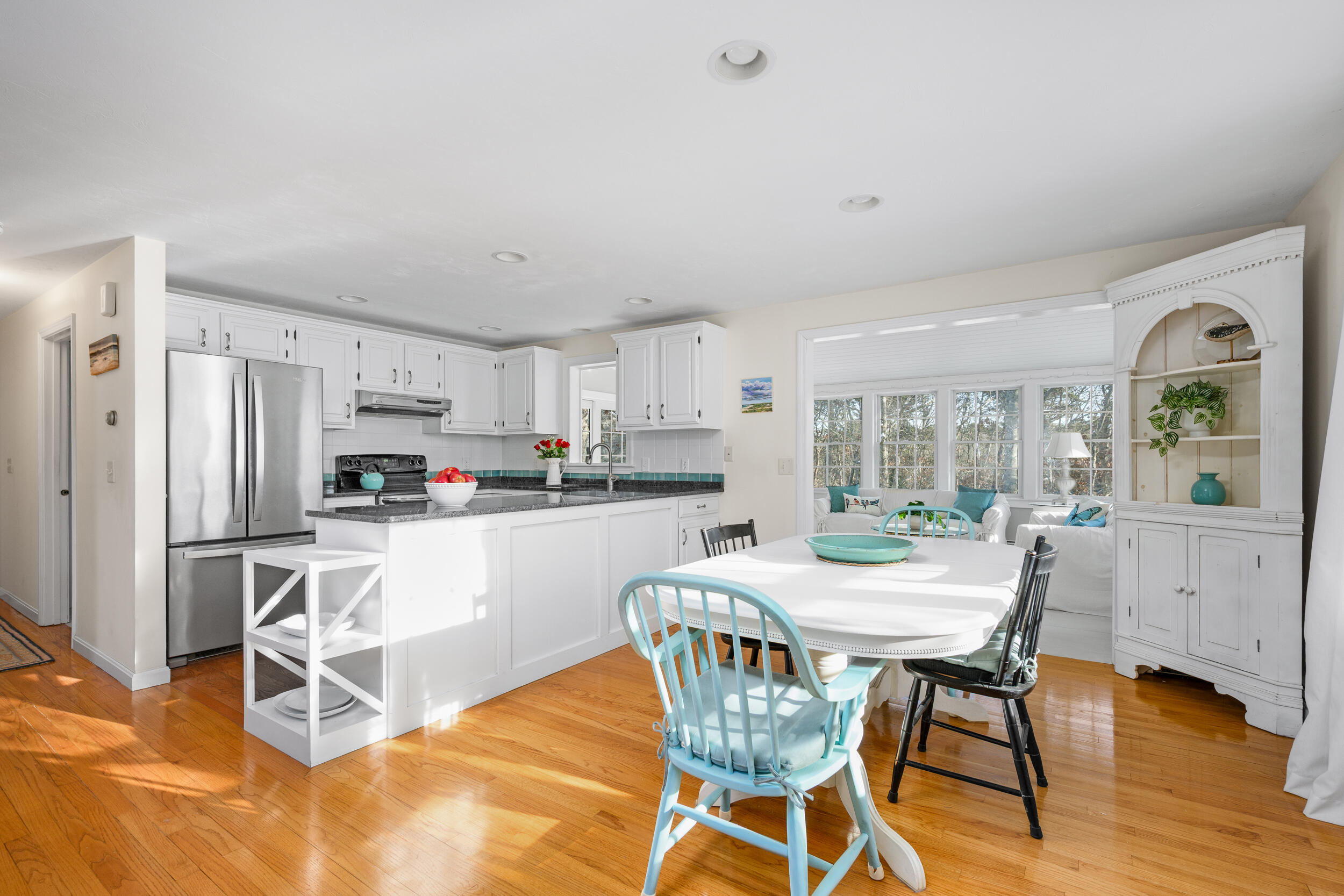 36 Island Street East Dennis, MA 02660 - Photo 9 of 41 a kitchen with stainless steel appliances a dining table chairs refrigerator and sink