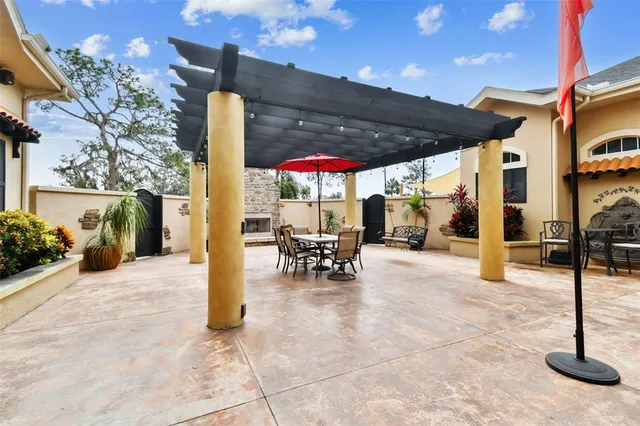 a view of a patio with a table and chairs under an umbrella
