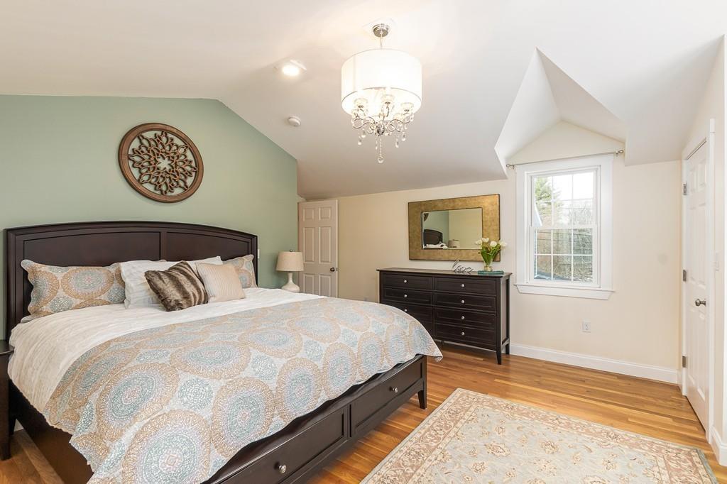 24 Wheeler Road Bolton, MA 01740 - Photo 20 of 28 a bedroom with a bed and a chandelier