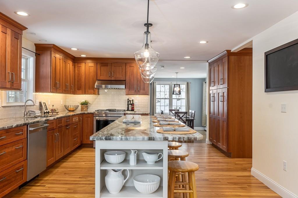 24 Wheeler Road Bolton, MA 01740 - Photo 2 of 28 a kitchen with stainless steel appliances granite countertop wooden cabinets a center island and a refrigerator