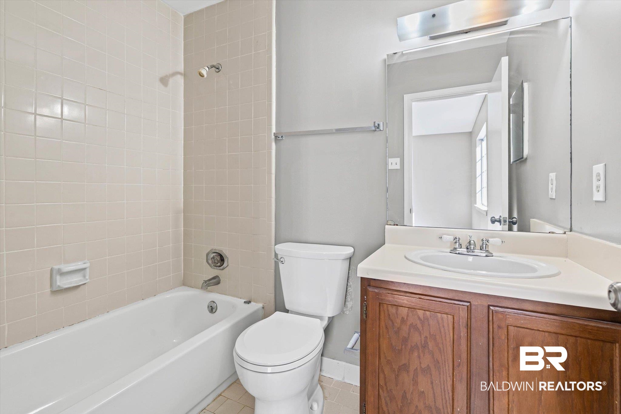 6701 Dickens Ferry Road, Unit 100 Mobile, AL 36608 - Photo 12 of 24 Bathroom with washtub / shower combination, vanity, and light tile patterned flooring
