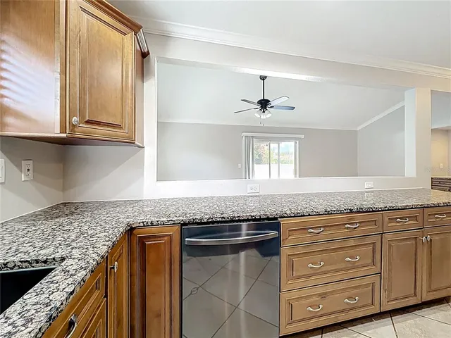 a kitchen with granite countertop a refrigerator stove and microwave