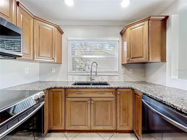 a kitchen with stainless steel appliances granite countertop a refrigerator and a sink