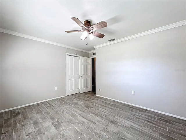 a view of an empty room with wooden floor