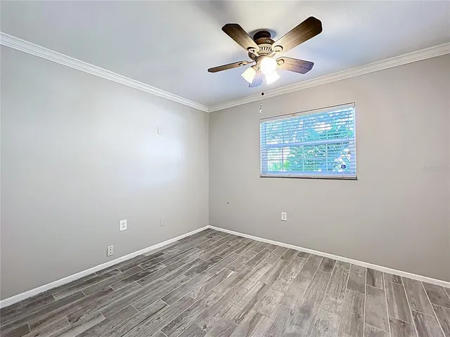 a view of empty room with wooden floor