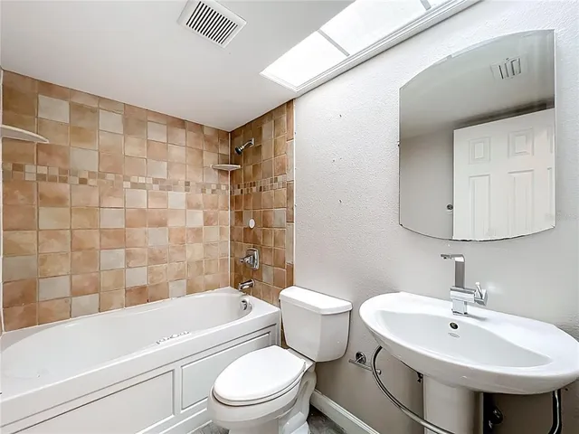 a bathroom with a toilet sink shower and mirror