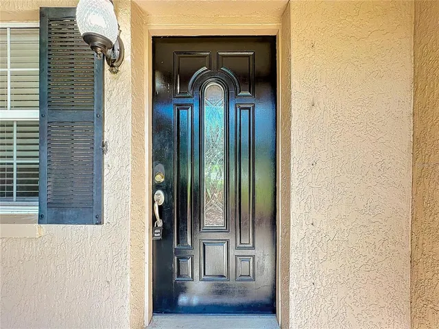 a view of an empty room with wooden floor and windows