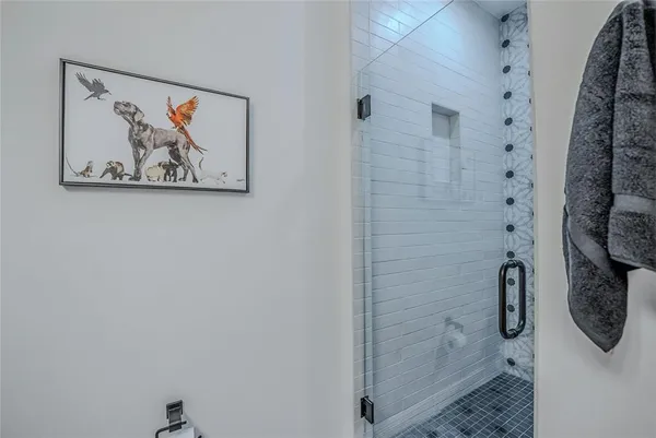 a bathroom with a shower and a painting on the wall