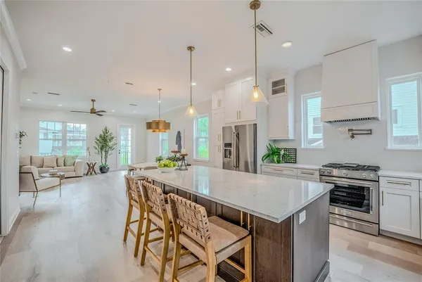 a kitchen with a table chairs stove and wooden floor