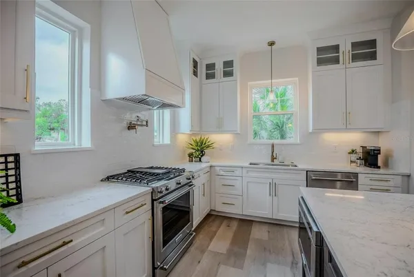 a kitchen with stainless steel appliances granite countertop sink stove and refrigerator