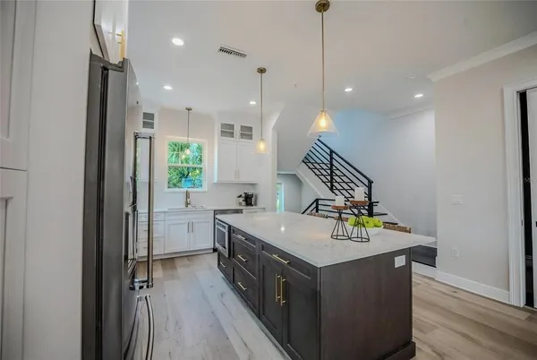 a kitchen with a sink appliances and wooden floor
