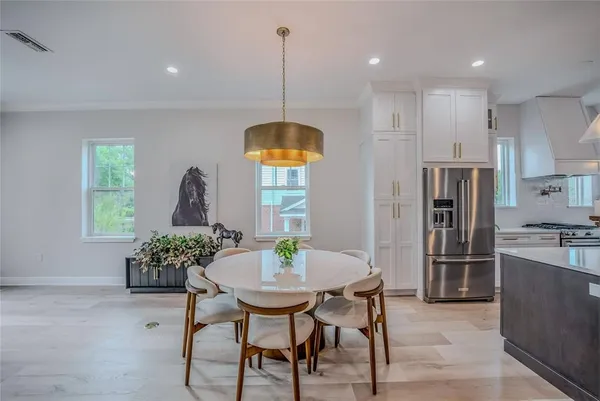 a kitchen with stainless steel appliances kitchen island granite countertop a table and chairs in it