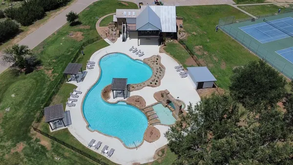 an aerial view of a house with outdoor space and swimming pool