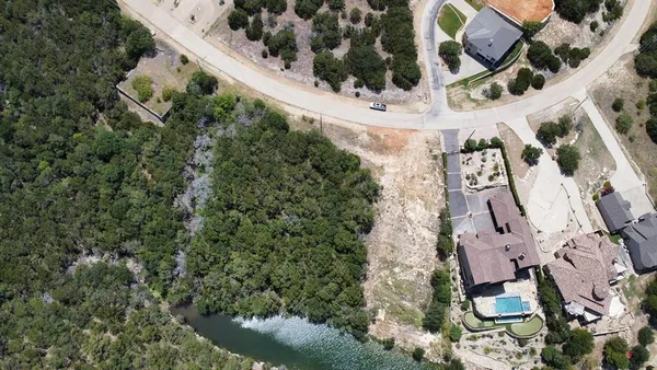 an aerial view of a house with a yard and parking