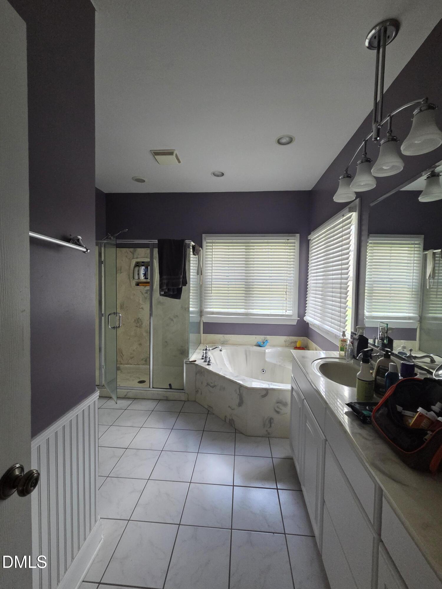 3001 Hidden Spring Lane Oxford, NC 27565 - Photo 42 of 57 a spacious bathroom with a double vanity sink a large mirror and a bathtub