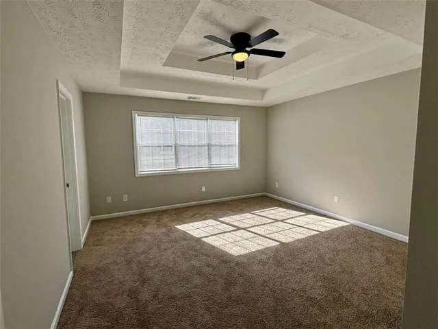 an empty room with a window and a ceiling fan