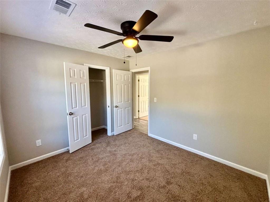 275 Thorn Brook Circle Bethlehem, GA 30620 - Photo 18 of 32 an empty room with ceiling fan and window
