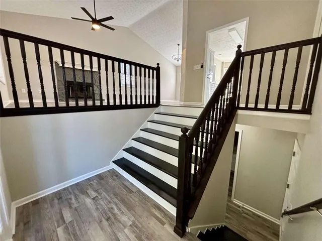 a view of staircase with wooden floor and white walls