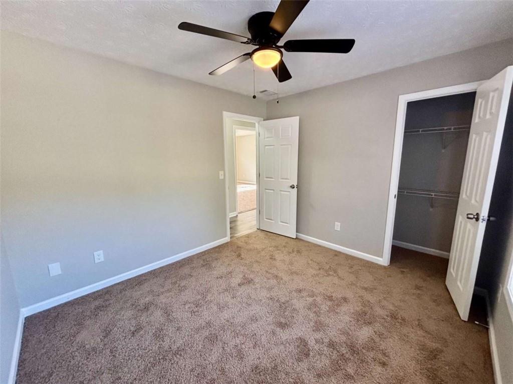 275 Thorn Brook Circle Bethlehem, GA 30620 - Photo 21 of 32 an empty room with closet and a chandelier fan