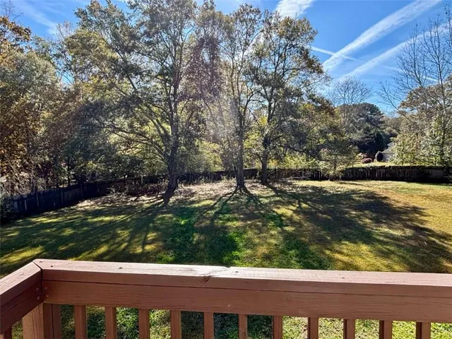 a view of a yard with wooden fence