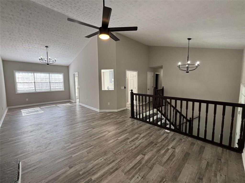 275 Thorn Brook Circle Bethlehem, GA 30620 - Photo 6 of 32 an empty room with wooden floor chandelier and windows