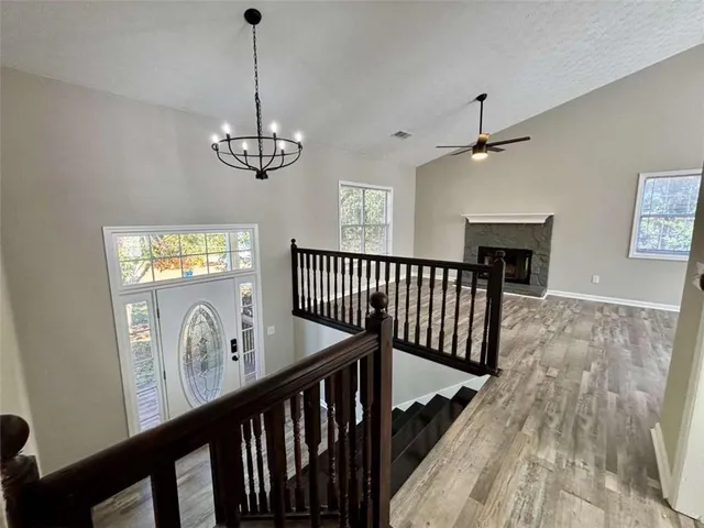 a view of a hallway with wooden floor and windows