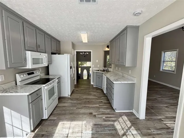 a kitchen with a sink a stove top oven and refrigerator