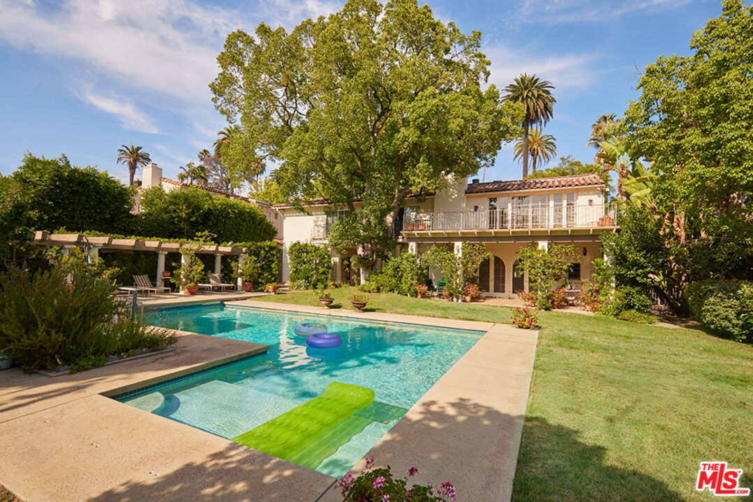 623 North Hillcrest Road Beverly Hills, CA 90210 - Photo 1 of 24 a front view of a house with swimming pool having outdoor seating