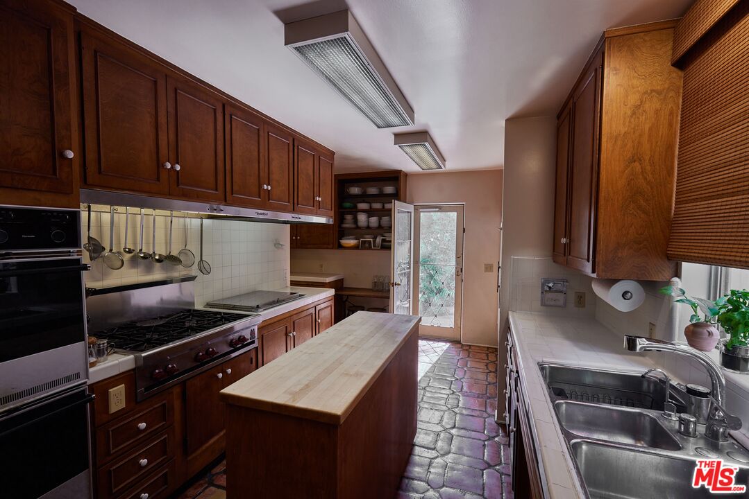 623 North Hillcrest Road Beverly Hills, CA 90210 - Photo 11 of 24 a kitchen with a sink stove and refrigerator