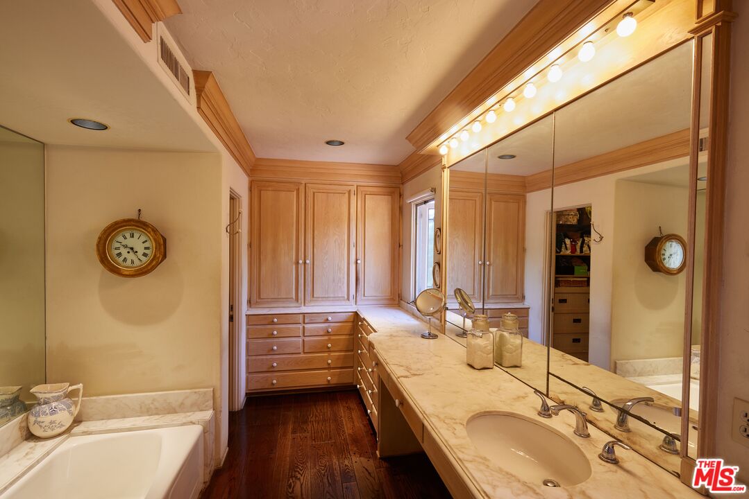 623 North Hillcrest Road Beverly Hills, CA 90210 - Photo 15 of 24 a bathroom with a granite countertop sink and a large mirror