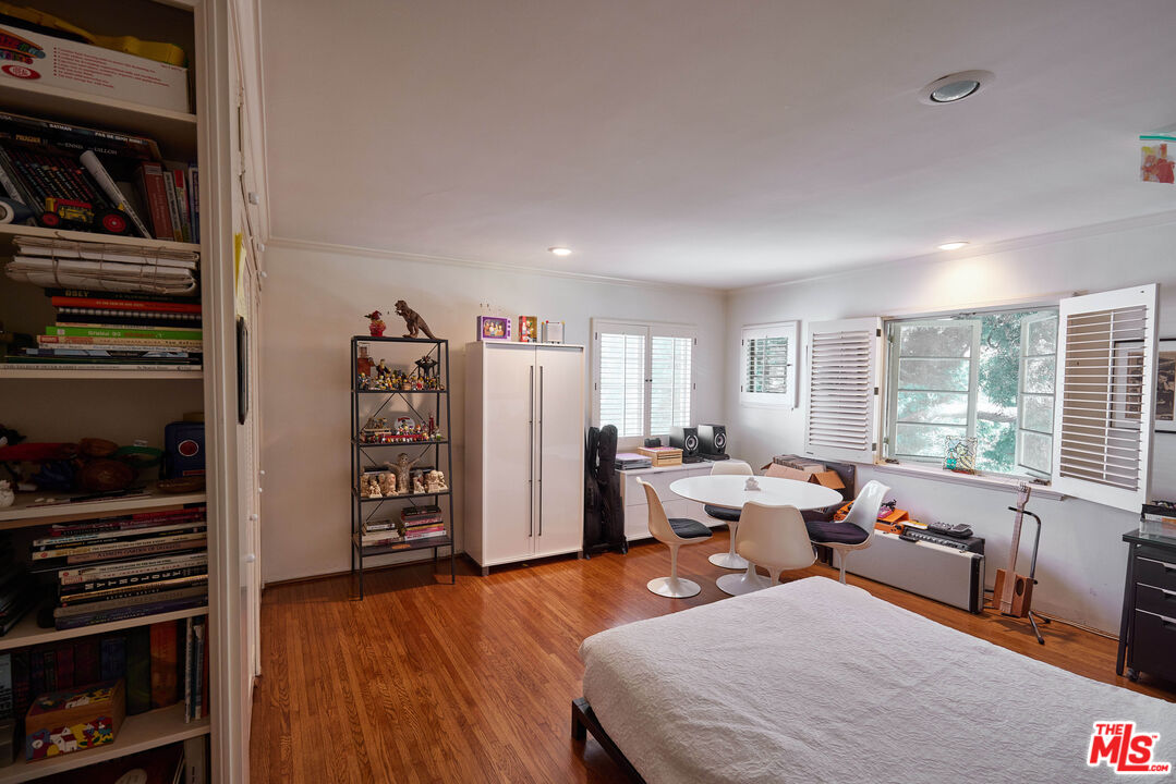 623 North Hillcrest Road Beverly Hills, CA 90210 - Photo 16 of 24 a bedroom with furniture and a large window