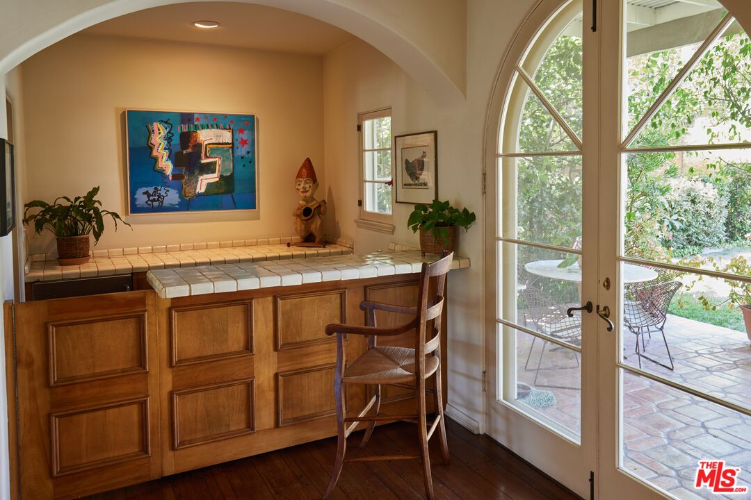 623 North Hillcrest Road Beverly Hills, CA 90210 - Photo 5 of 24 a dining room with wooden floor and a floor to ceiling window