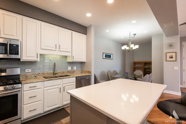 a kitchen with stainless steel appliances a white cabinets sink and stove top oven