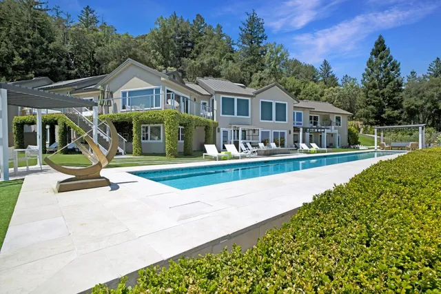 an aerial view of residential houses with outdoor space and trees