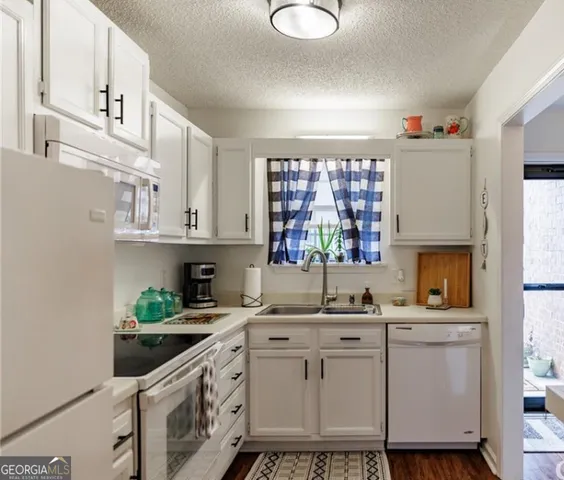 a kitchen with white cabinets and sink