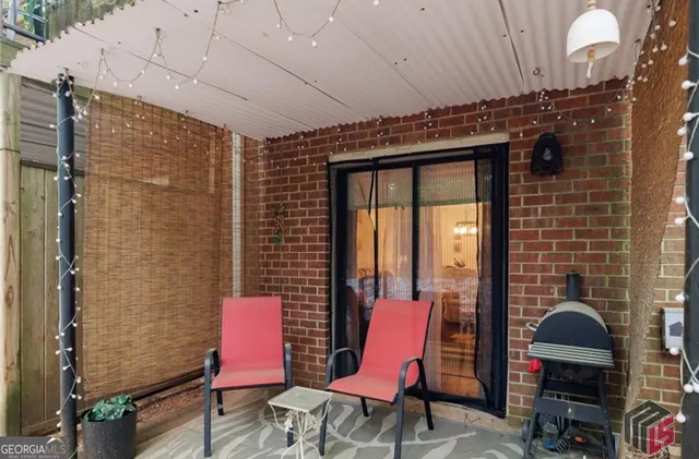 a view of a patio with a table and chairs and a barbeque