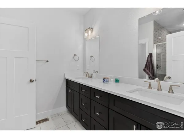 a bathroom with double vanity sink and a mirror