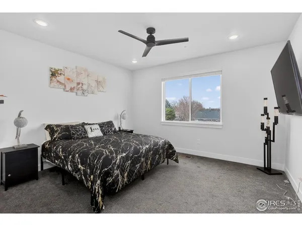 a bedroom with bed tv and window