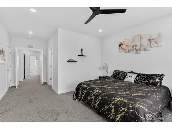 a bedroom with a bed and painting on the wall