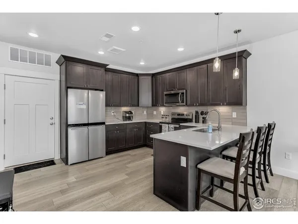 a kitchen with refrigerator cabinets and wooden floor