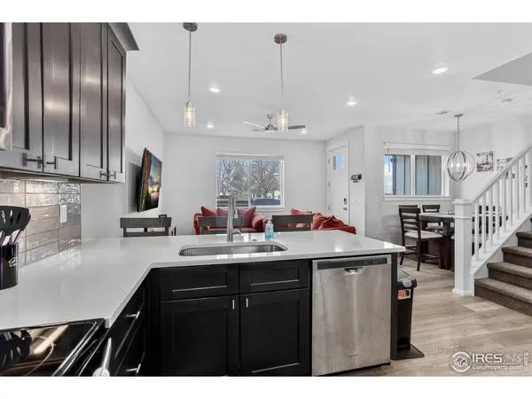 a kitchen with kitchen island granite countertop a sink stainless steel appliances and cabinets